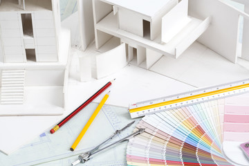 Architectural model with other office stationery on blueprints