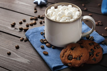 Mug of hot chocolate with marshmallows, on wooden background