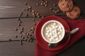 Mug of hot chocolate with marshmallows, on wooden background