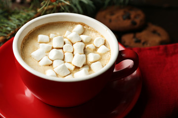 Mug of hot chocolate with marshmallows, on wooden background