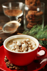 Mug of hot chocolate with marshmallows, fir tree branch on wooden background