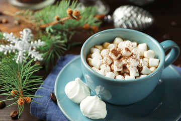 Obraz na płótnie Canvas Mug of hot chocolate with marshmallows, fir tree branch on wooden background