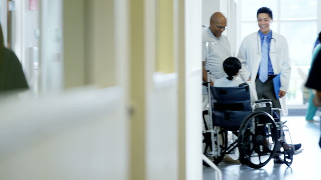 African American disabled female on wheelchair and husband in medical center