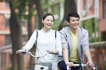 Young couple  riding bicycle on campus