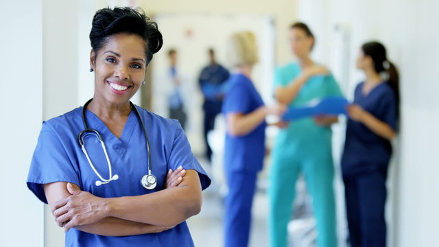 Portrait of confident African American female staff in medical center corridor