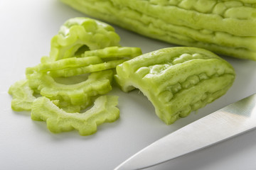 green bitter gourd or melon sliced on white background