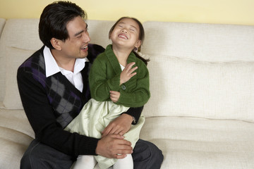Father And Daughter Laughing Together