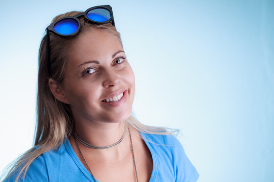 Smiling Beautiful Woman With Blue Sunglasses Over Her Head