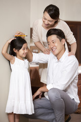 Fototapeta premium Parents measuring height for daughter