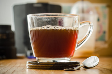 The cup of hot coffee on wooden background in the morning