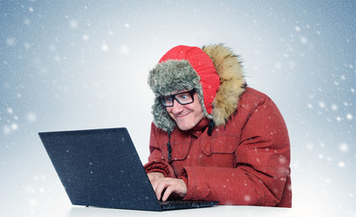 Programmer with a laptop in the winter blizzard