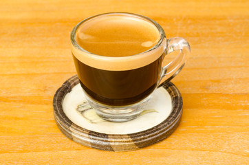 The cup of hot coffee (espresso) on wooden background