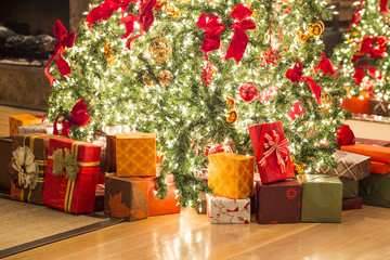 many gifts and beautiful Christmas tree on floor