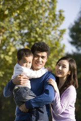 Fototapeta premium Portrait of young family at the park
