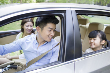 Happy young family in a car