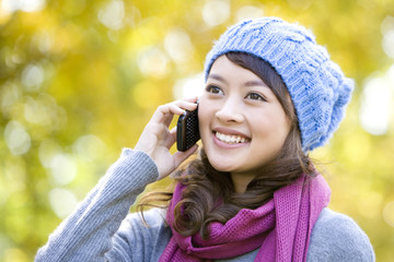 Young Woman Talking on a Mobile Phone in a Park