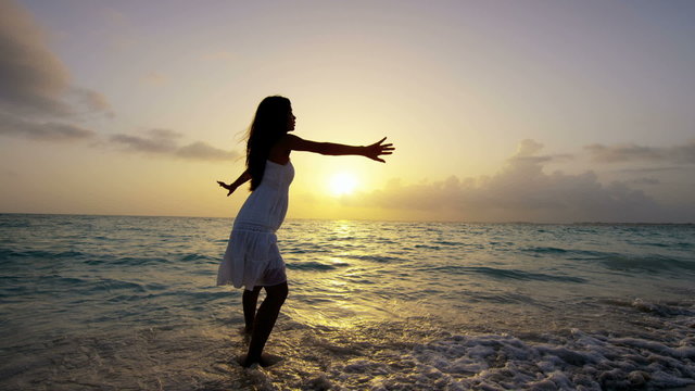 Barefoot Asian Chinese girl at sunset on tropical beach