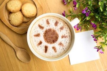 coffee time with latte art in sun design and butter cookies on wooden table, vintage color tone