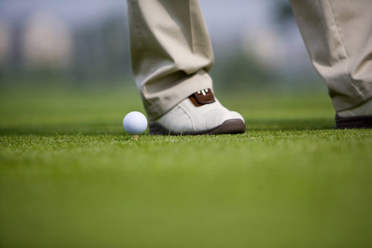 Close-up of a golf ball and Golfer's feet 