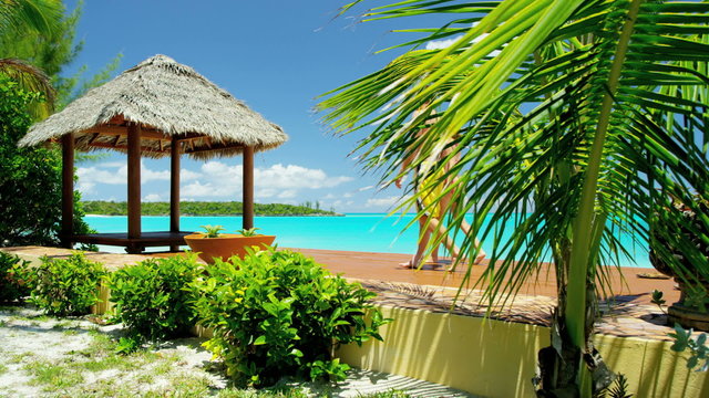 Caucasian couple sitting in a Caribbean tiki hut