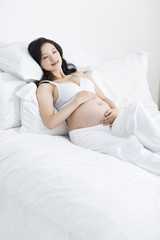 Obraz na płótnie Canvas Pregnant woman sleeping in bed