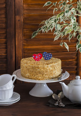 Homemade cake on a ceramic stand for the cake, tea set, paper hearts, a flower. Valentine's day romantic Breakfast. Vintage and rustic style