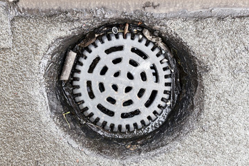Old steel rusty grating on the ground with trash on it.