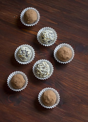 Assorted homemade dark chocolate truffles on dark wooden background