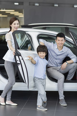 Young family choosing car in showroom