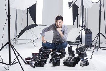 Photographer in studio with many cameras on the ground