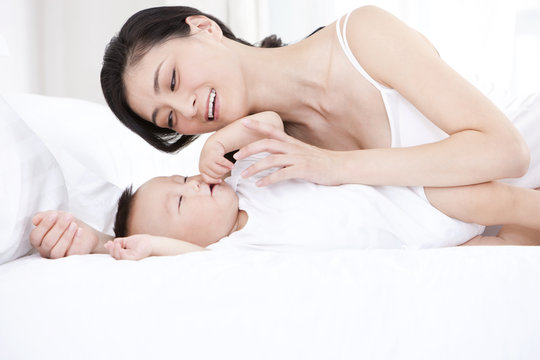 Tender mother putting baby to sleep