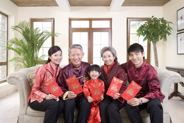 Fototapeta premium Three generation family holding Chinese new year red envelope