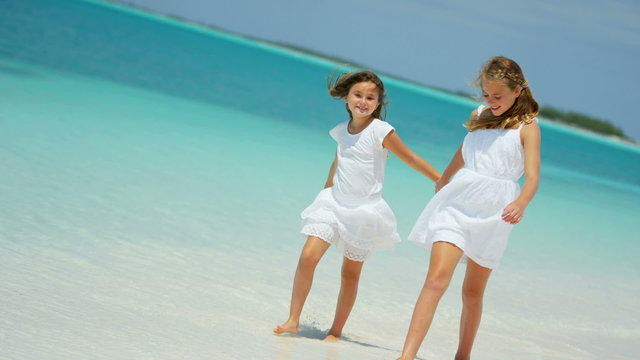 Caucasian young happy female children sisters outdoor coast luxury island 