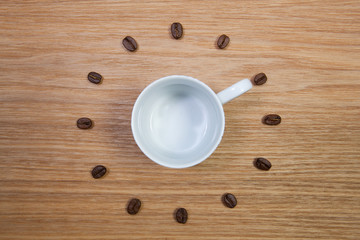 Empty coffee cup and clock of coffee beans