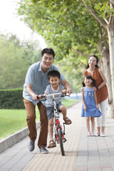 Young father teaching his son to ride a bicycle