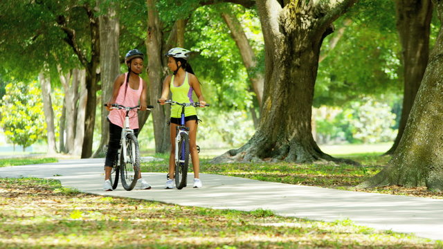 Young happy multi ethnic American women cycling to keep healthy