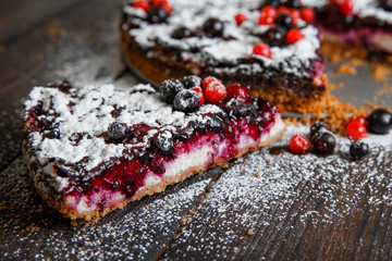 Piece of homemade berry cake on the wood background