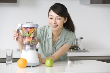 Woman making fresh fruit juice