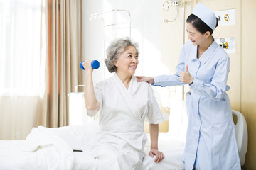 Fototapeta premium Nurse helping senior woman doing rehabilitation training