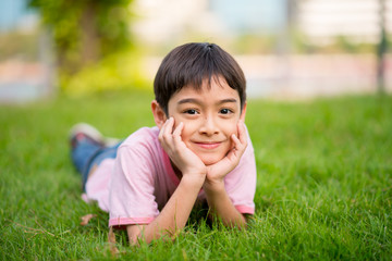 Little boy lay down on the grass  with smile