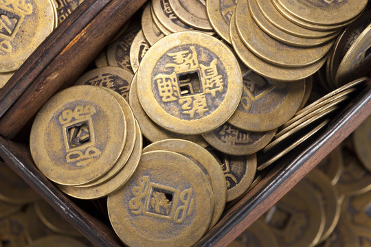 Close-up of a wooden box full of ancient Chinese coins
