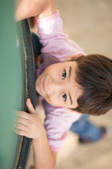 Fototapeta na wymiar Little boy climping up brave at playground