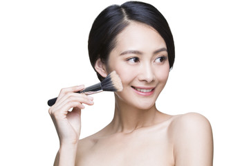 Beautiful young woman with cosmetic brush