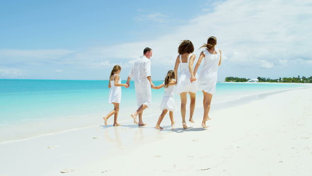 loving Caucasian parents female children healthy outdoor luxury beach ocean 