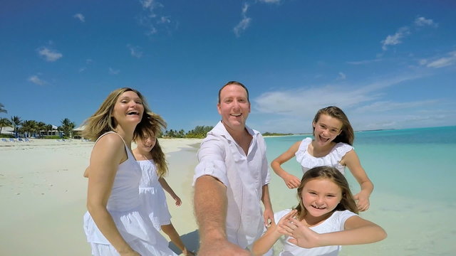 Selfie portrait of happy young Caucasian family on beach 