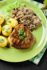 Fried pork schnitzel served with boiled potatoes and fried sauer