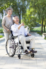 Obraz na płótnie Canvas Senior woman with wheelchair bound husband