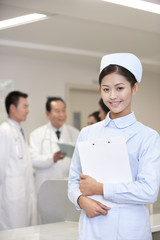 Portrait of a confident nurse standing in front of her colleagues