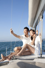Happy couple taking self portrait on the boat deck
