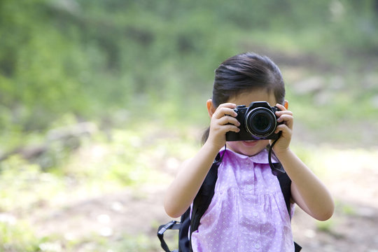 Little girl taking photos in nature